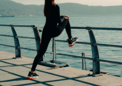 Frau macht Sport und dehnt sich am Ufer eines Flusses